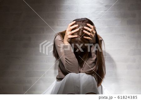 頭を抱える女性 61824385