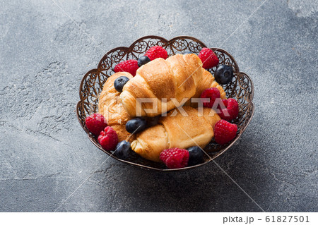 Croissants with fresh raspberries and blueberries 61827501