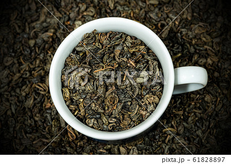 Dried leaves of green gunpowder tea in a white cup 61828897