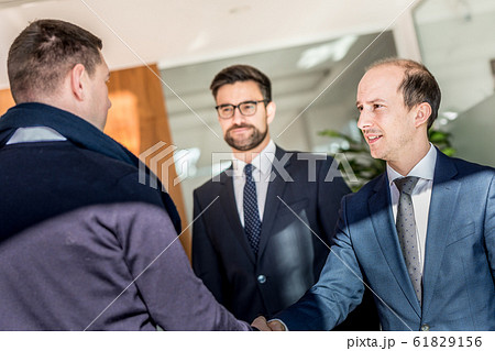 Group of confident business people greeting with a handshake at business meeting in modern office or closing the deal agreement by shaking hands. Group of confident business people greeting with a handshake at business meeting in modern office or closing the deal agreement by shaking hands. 61829156