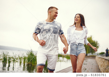 Beautiful couple spend time in a autumn cloudy park Beautiful couple spend time in a autumn cloudy park 61830761
