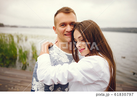 Beautiful couple spend time in a autumn cloudy park Beautiful couple spend time in a autumn cloudy park 61830797
