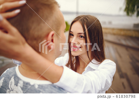 Beautiful couple spend time in a autumn cloudy park Beautiful couple spend time in a autumn cloudy park 61830798
