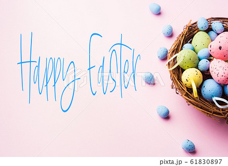 Colorful decor easter eggs in a nest on pink 61830897