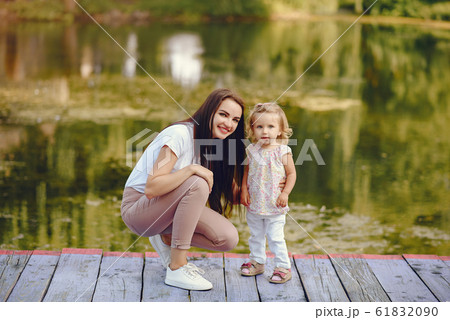 Mother with daughter playing in a summer park Mother with daughter playing in a summer park 61832090