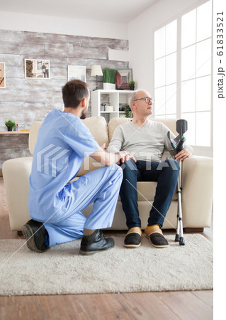 Young doctor in nursing home talking with old man Young doctor in nursing home talking with old man 61833521