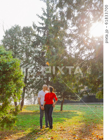 Happy lovers in the park at thuja in autumn sunny 61833700