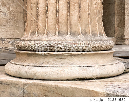Base of a Greek stone column at the Parthenon of Acropolis in Athens, Greece. Detail of a temple pillar with a decorative ornament. Compression member and structural element. Classical Greece. Photo. Base of a Greek stone column at the Parthenon of Acropolis in Athens, Greece. Detail of a temple pillar with a decorative ornament. Compression member and structural element. Classical Greece. Photo. 61834682
