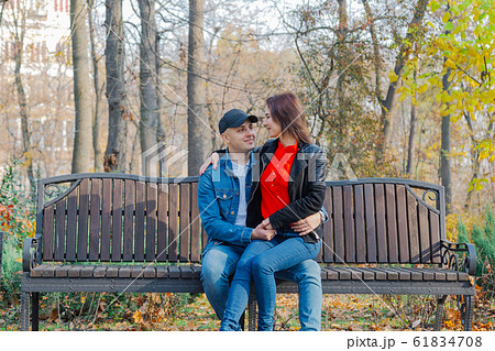 Happy lovers in the park on a bench in autumn. Happy lovers in the park on a bench in autumn. 61834708