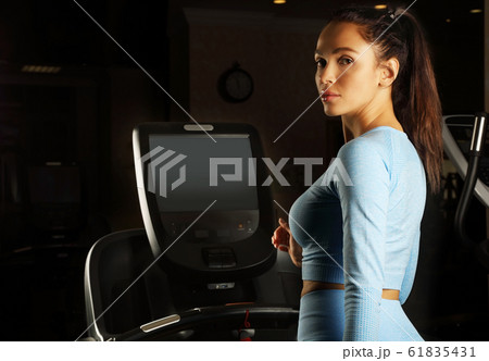 Young attractive woman running on a treadmill 61835431