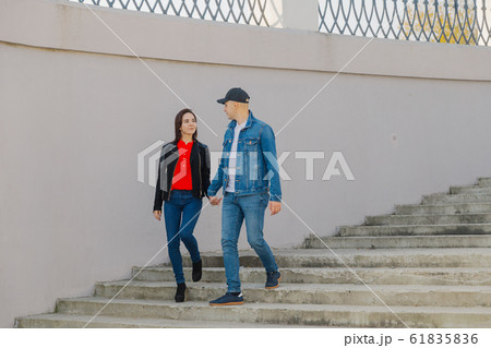 Loving couple walk up the concrete stairs and hold Loving couple walk up the concrete stairs and hold 61835836