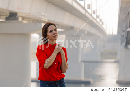 Beautiful girl stands at the bridge near the river 61836047