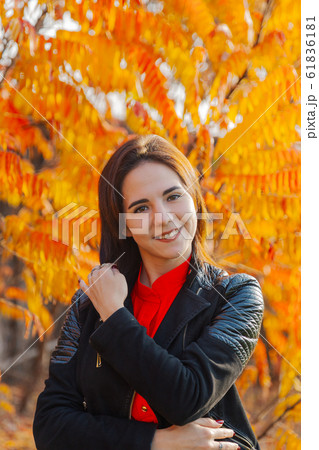 Girl on a background of yellow leaves in autumn. 61836181