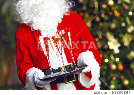 Santa Claus holding champagne glasses on the tray 61839897