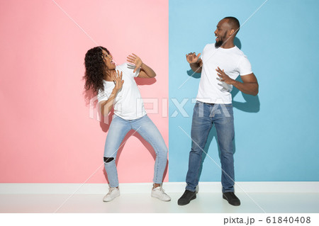 Young emotional man and woman on pink and blue background Young emotional man and woman on pink and blue background 61840408