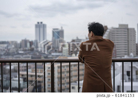 コートを着た中高年男性の後ろ姿の写真素材