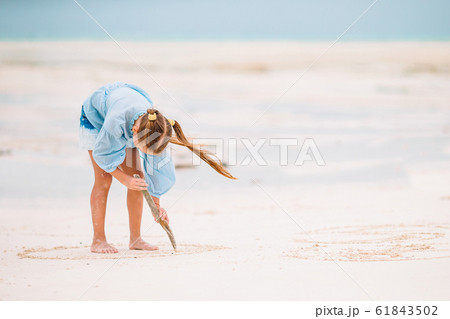 Adorable active little girl at beach during summer vacation Adorable active little girl at beach during summer vacation 61843502