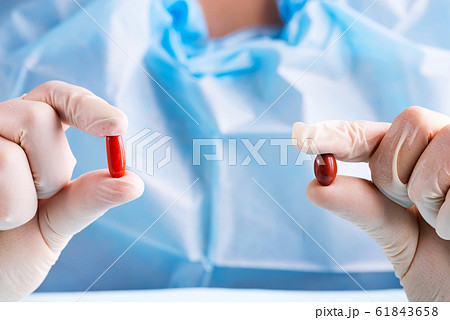 Close-up of a doctor's hand holding assorted medicines pills Close-up of a doctor's hand holding assorted medicines pills 61843658