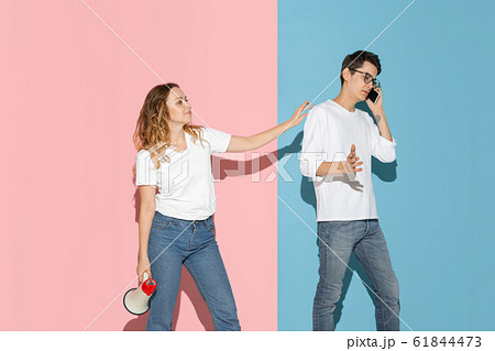 Young emotional man and woman on pink and blue background Young emotional man and woman on pink and blue background 61844473