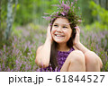 Happy girl is wearing heather wreath 61844527
