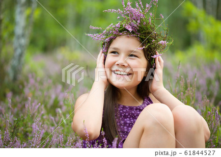 Happy girl is wearing heather wreath 61844527