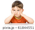 Sad little boy is sitting at table supporting his 61844551