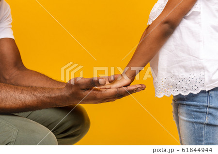 Black dad holding his little daughter hands Black dad holding his little daughter hands 61844944