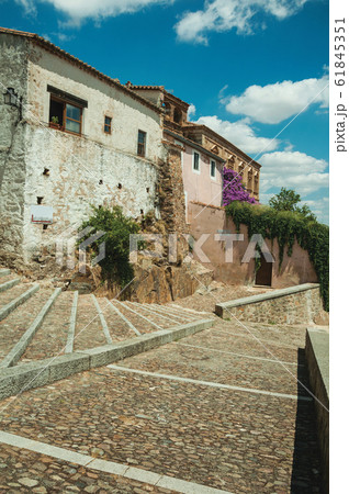 Buildings and flowering trees over a stairway in Caceres 61845351