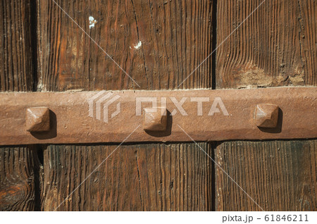 Iron hinge with studs in an old wooden door 61846211