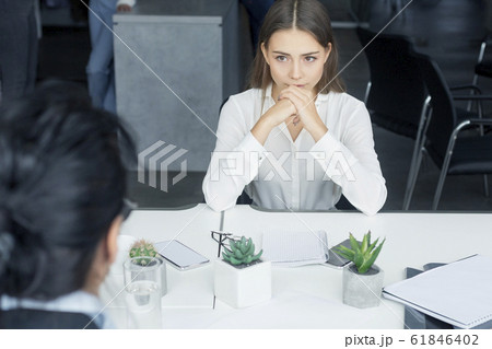 Nervous female applicant waiting for result at job interview Nervous female applicant waiting for result at job interview 61846402