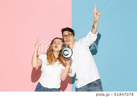 Young emotional man and woman on pink and blue background 61847078