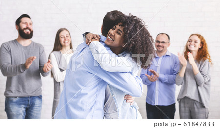 Diverse people hugging after successful workshop or seminar Diverse people hugging after successful workshop or seminar 61847833