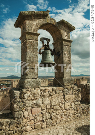Bronze bell on top of stone wall at the Castle of Trujillo Bronze bell on top of stone wall at the Castle of Trujillo 61847949