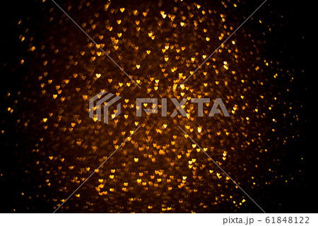 Dark background with golden bokeh in the shape of a heart. 61848122