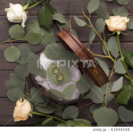 Creative marriage rings composition on pillow of green leaves 61848208