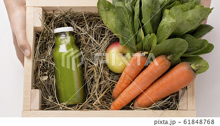 Woman farmer holding wooden box with detox drink 61848768