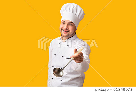 Cheerful Chef Holding Ladle Spoon Posing Over Yellow Background Cheerful Chef Holding Ladle Spoon Posing Over Yellow Background 61849073