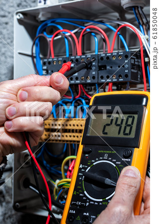 Electrician working on a residential electrical Electrician working on a residential electrical 61850048
