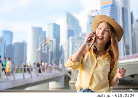 Young woman in calling on phone with friend during travel in Singapore Young woman in calling on phone with friend during travel in Singapore 61850204