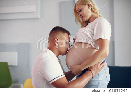 Beautiful pregnant woman with her husband in a studio Beautiful pregnant woman with her husband in a studio 61851245