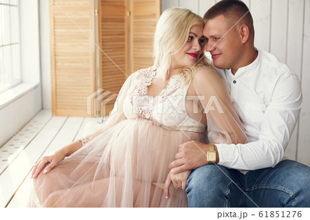 Beautiful pregnant woman with her husband in a studio Beautiful pregnant woman with her husband in a studio 61851276