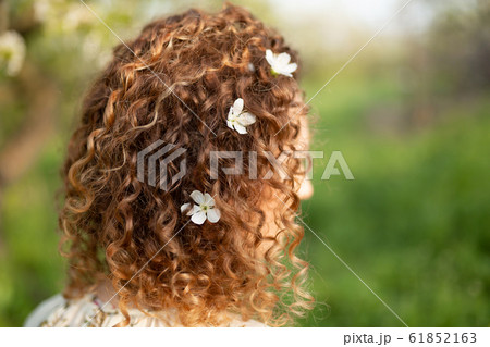Attractive young woman with white flowers woven in Attractive young woman with white flowers woven in 61852163