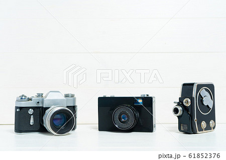 Vintage cameras on the white wooden background. Concept of old technology. Photo with place for text. Sweden. Vintage cameras on the white wooden background. Concept of old technology. Photo with place for text. Sweden. 61852376