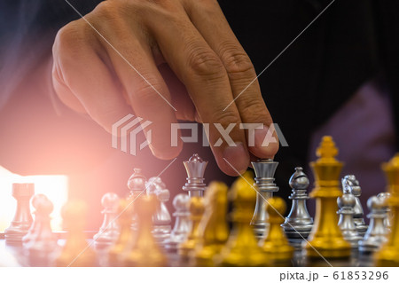 Chess game on chess board behind business man 61853296