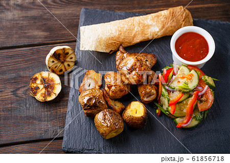 Grilled meat with potatoes and vegetable salad Grilled meat with potatoes and vegetable salad 61856718