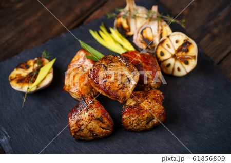 Grilled pork meat served on slate 61856809