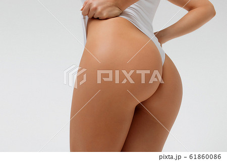 Crop sexy woman touching swimsuit posing in studio Crop sexy woman touching swimsuit posing in studio 61860086
