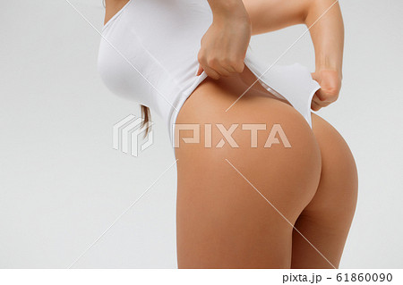 Crop sexy woman touching swimsuit posing in studio 61860090