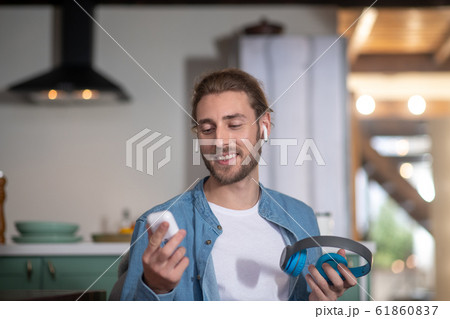 Young man testing different types of earphones Young man testing different types of earphones 61860837