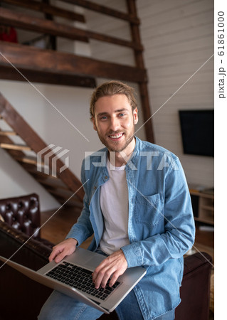 Smiling man working with his computer while staying at home 61861000